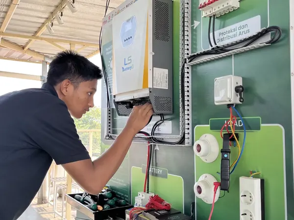Peserta Batch 1 merangkai inverter pada panel simulasi sistem PLTS